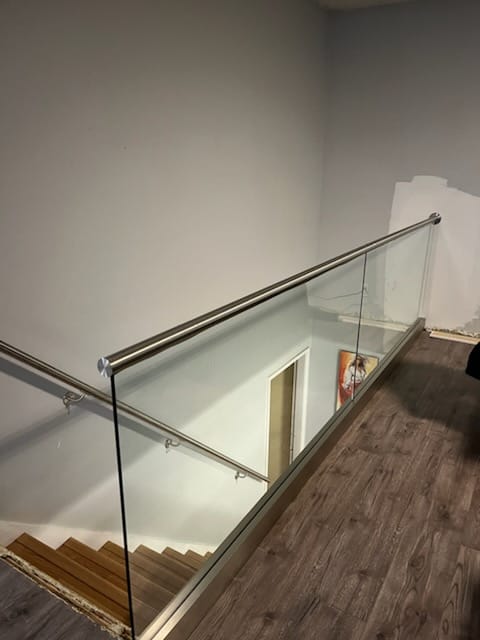 Staircase after — modern glass and steel railing
